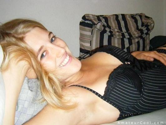 Fille amatrice blonde posant dans un corset et des bas