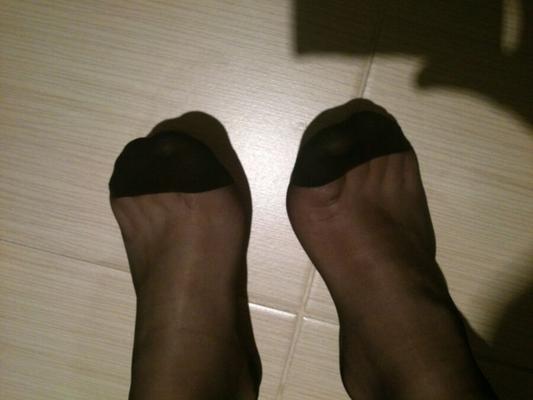 Pieds masculins en nylons noirs