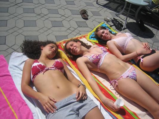 Des dames en bikini au bord de la piscine, à la maison, mais pas à la plage.