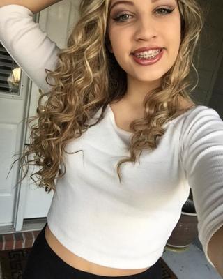 Linda joven animadora con un gran cuerpo, un gran cabello y frenillos