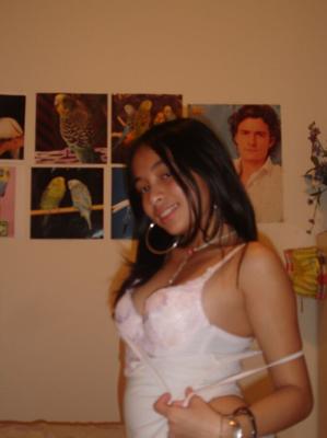 Latina super mignonne au lit, à genoux en soutien-gorge