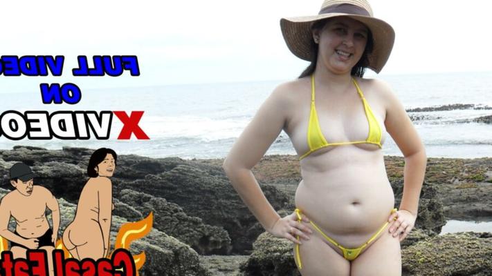 Esposa brasileña gordita caminando por la playa usando un micro bikini