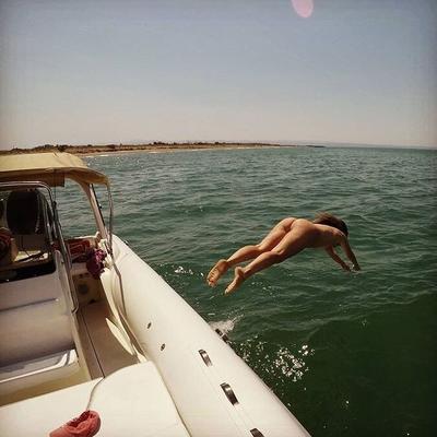 nudistas sumergiéndose buceando desde un barco